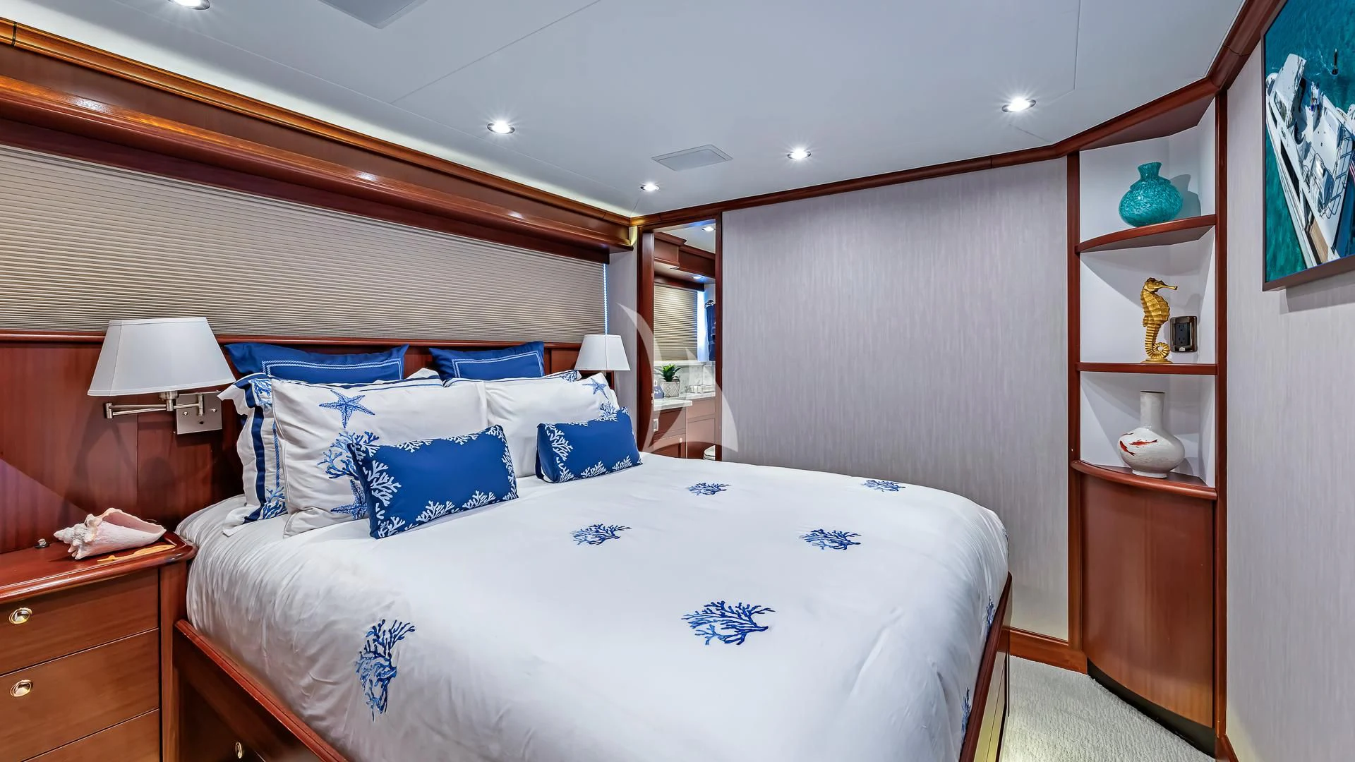 a bedroom with a bed and a shelf with a mirror aboard LADY B Yacht for Charter