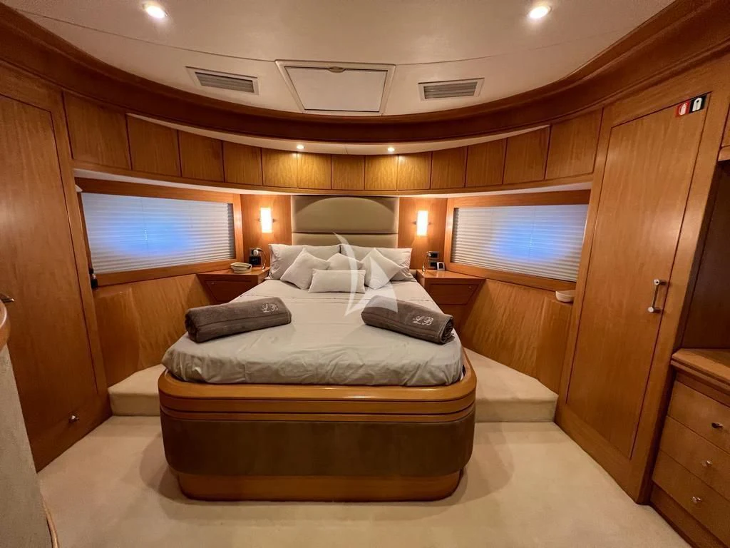 a bedroom with a bed and a tv aboard LADY B Yacht for Charter