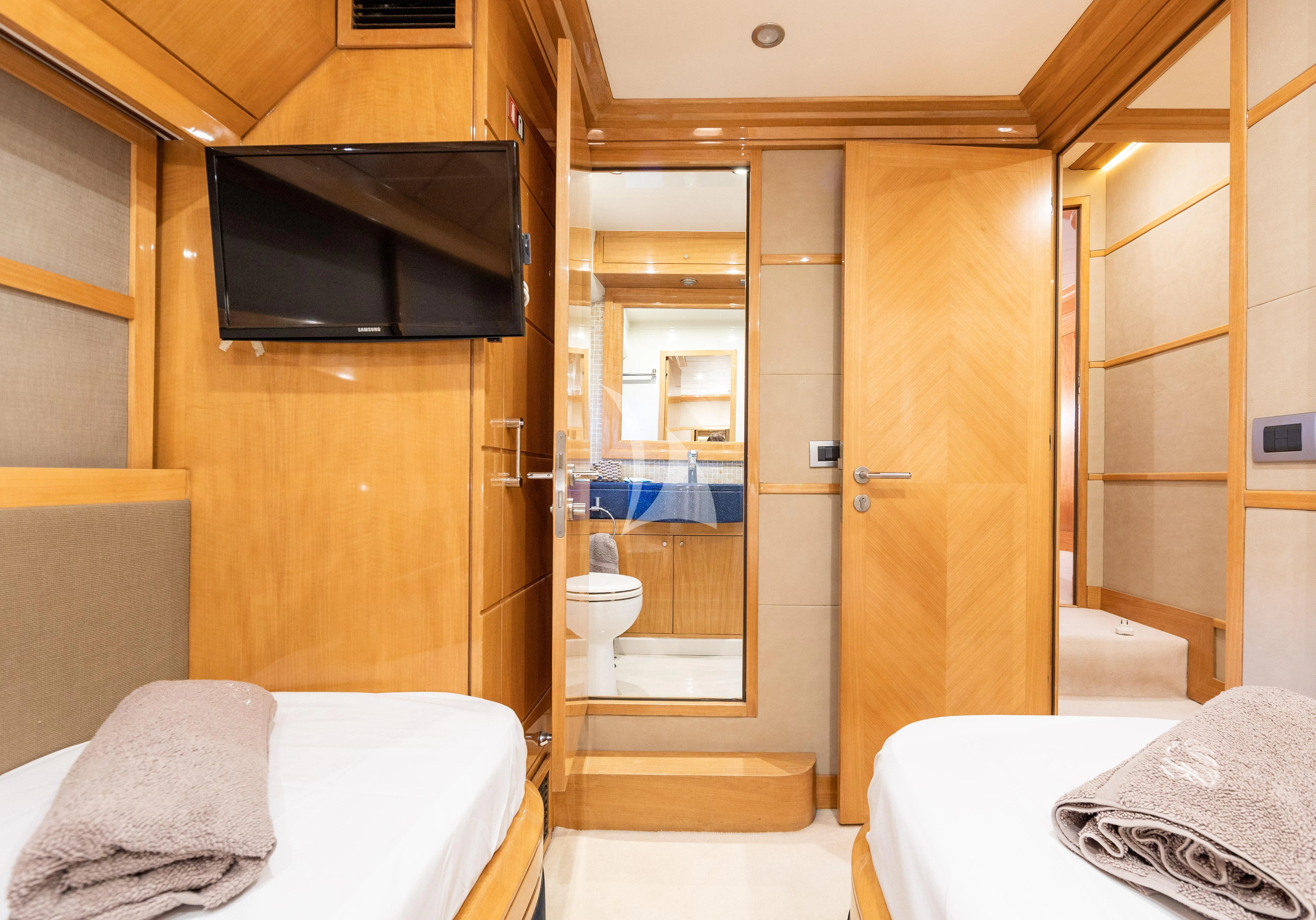 a hotel room with a bed and a television aboard LADY B Yacht for Charter