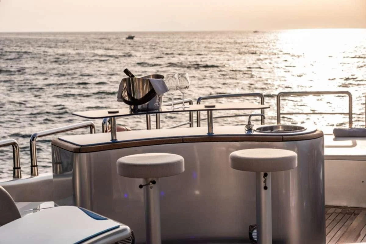 a table with chairs on it next to a body of water aboard LADY B Yacht for Charter