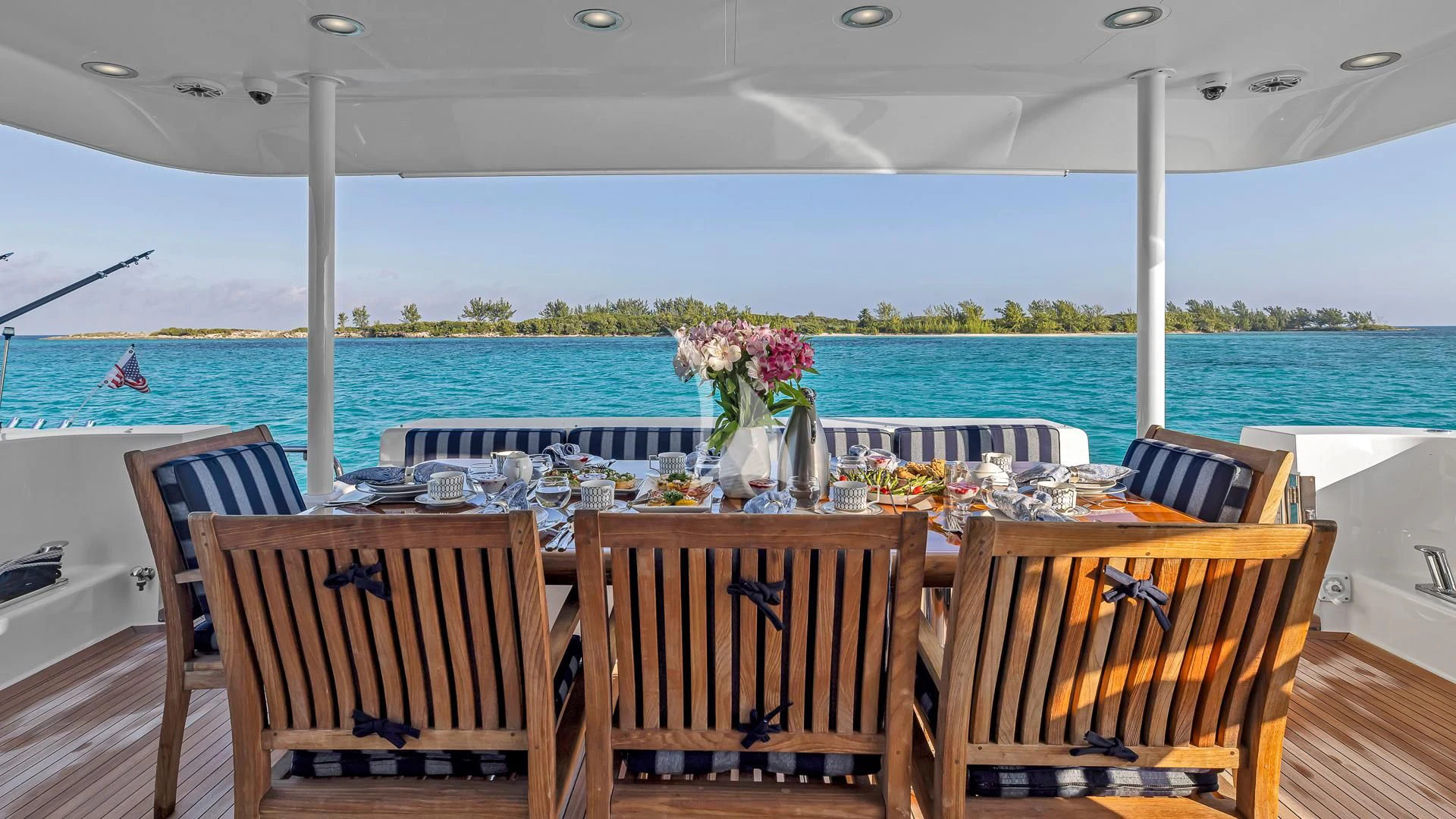 a table set for a meal on a deck overlooking a body of water aboard LADY B Yacht for Charter