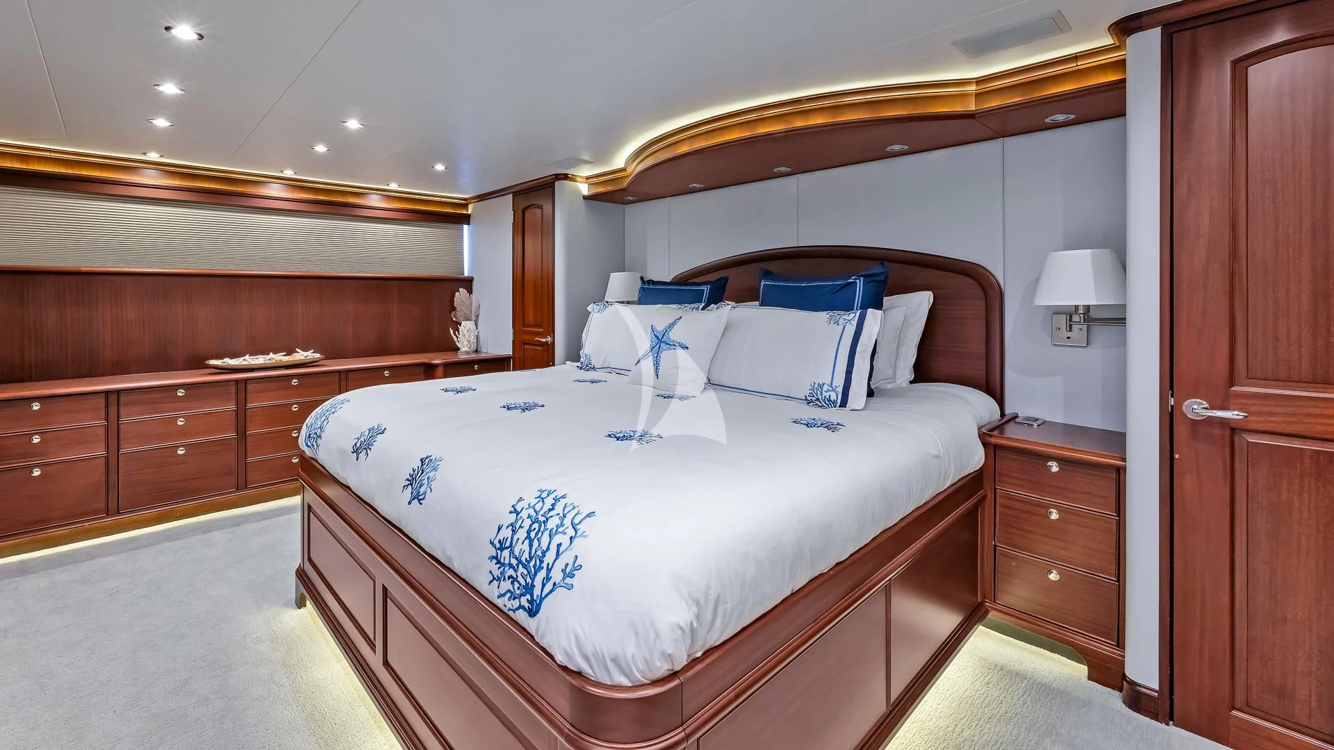a bed with a blue and white comforter and pillows aboard LADY B Yacht for Charter