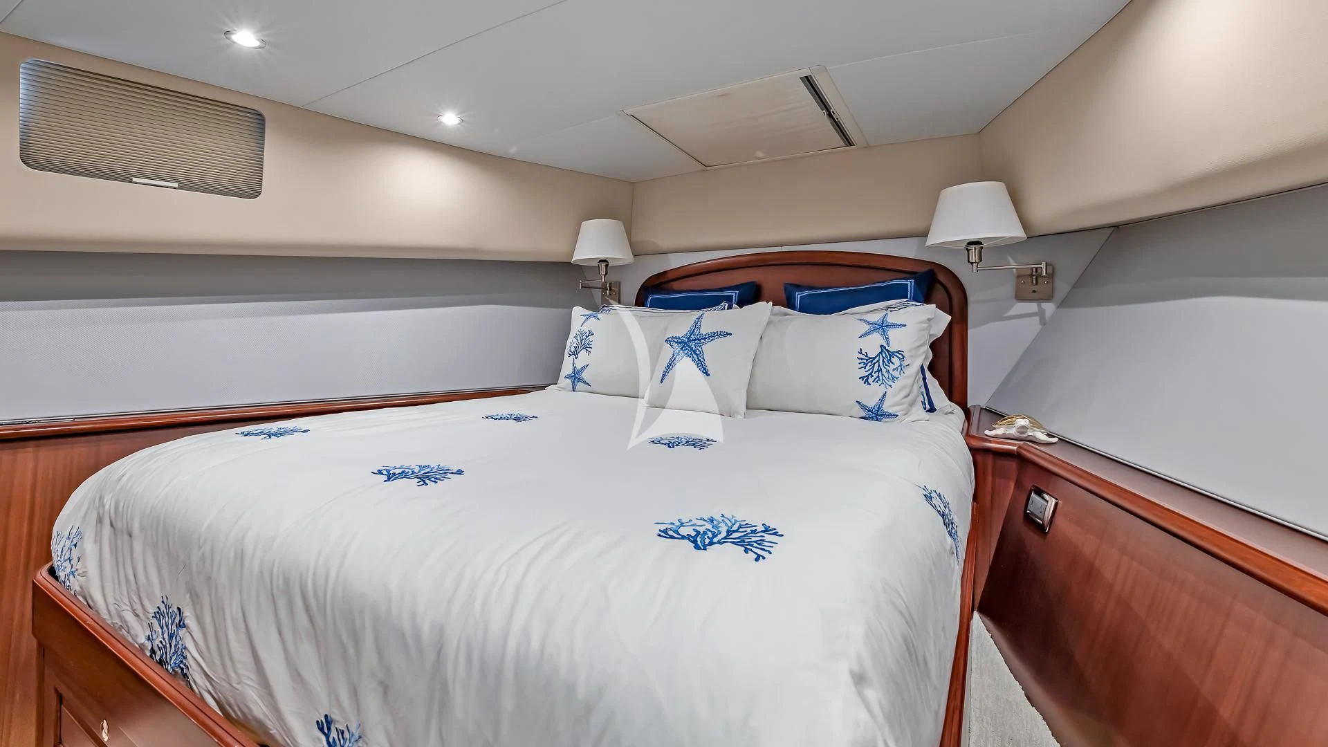 a bedroom with a bed and a lamp aboard LADY B Yacht for Charter