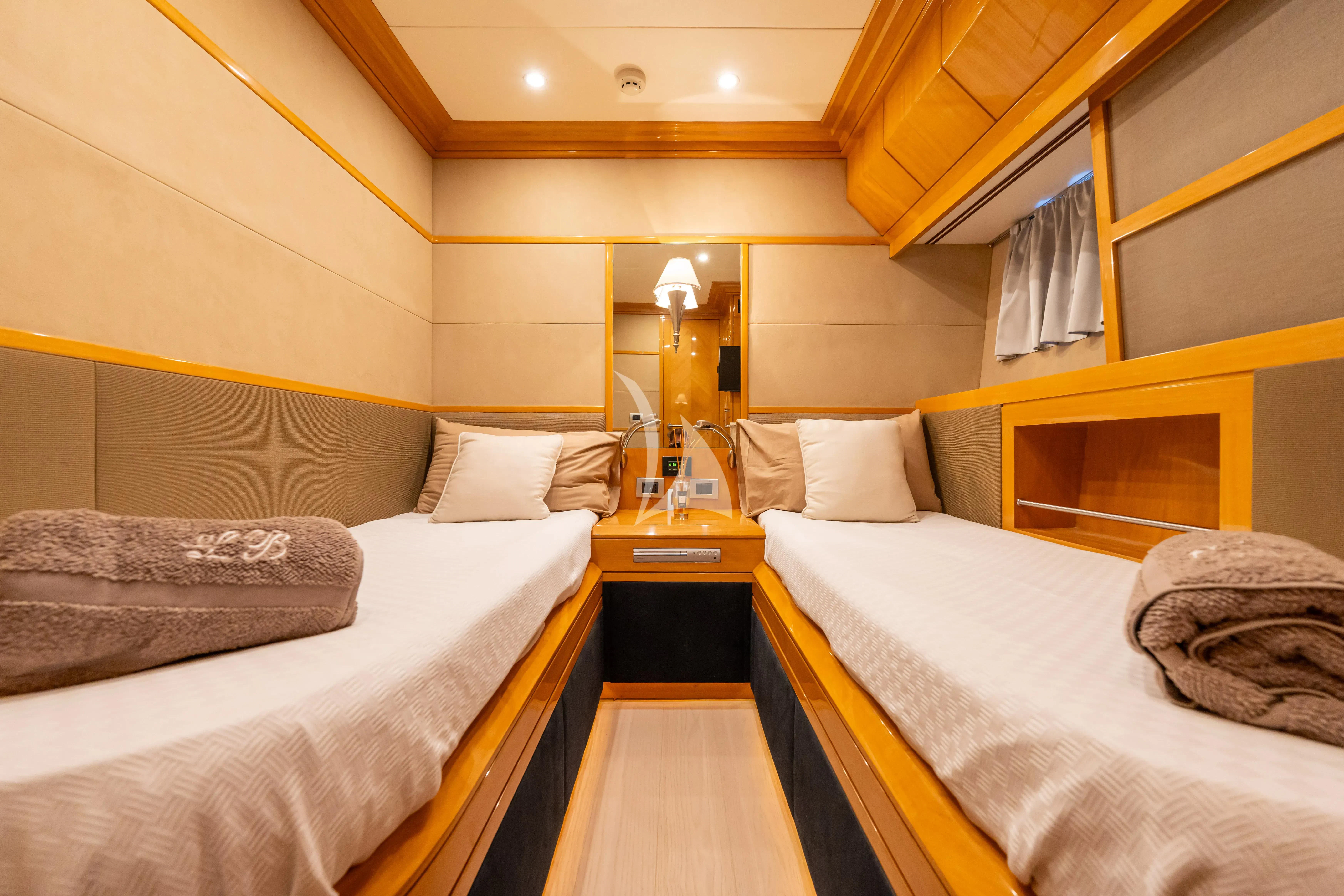 a room with beds and a lamp aboard LADY B Yacht for Charter