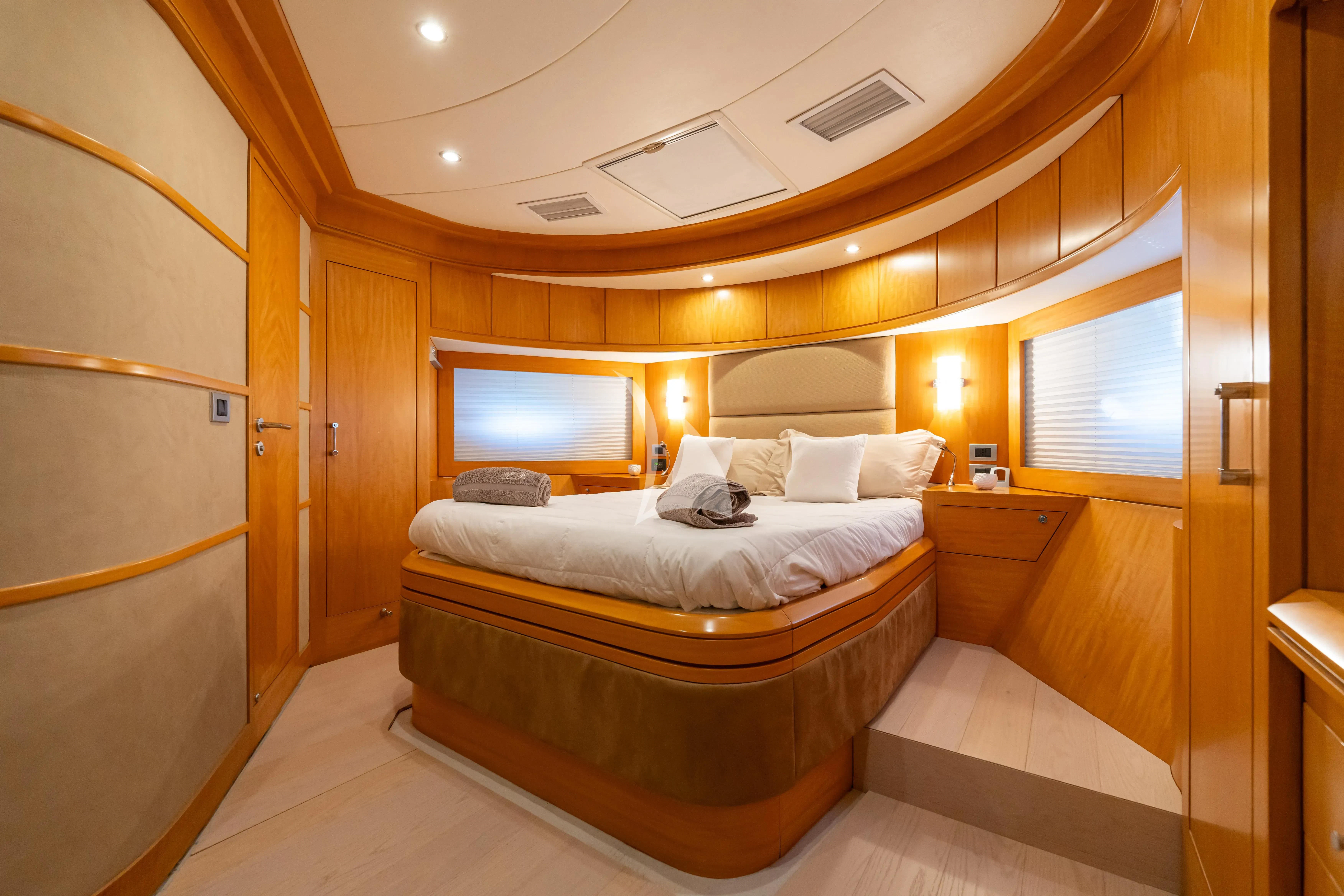 a room with a bed and a television aboard LADY B Yacht for Charter