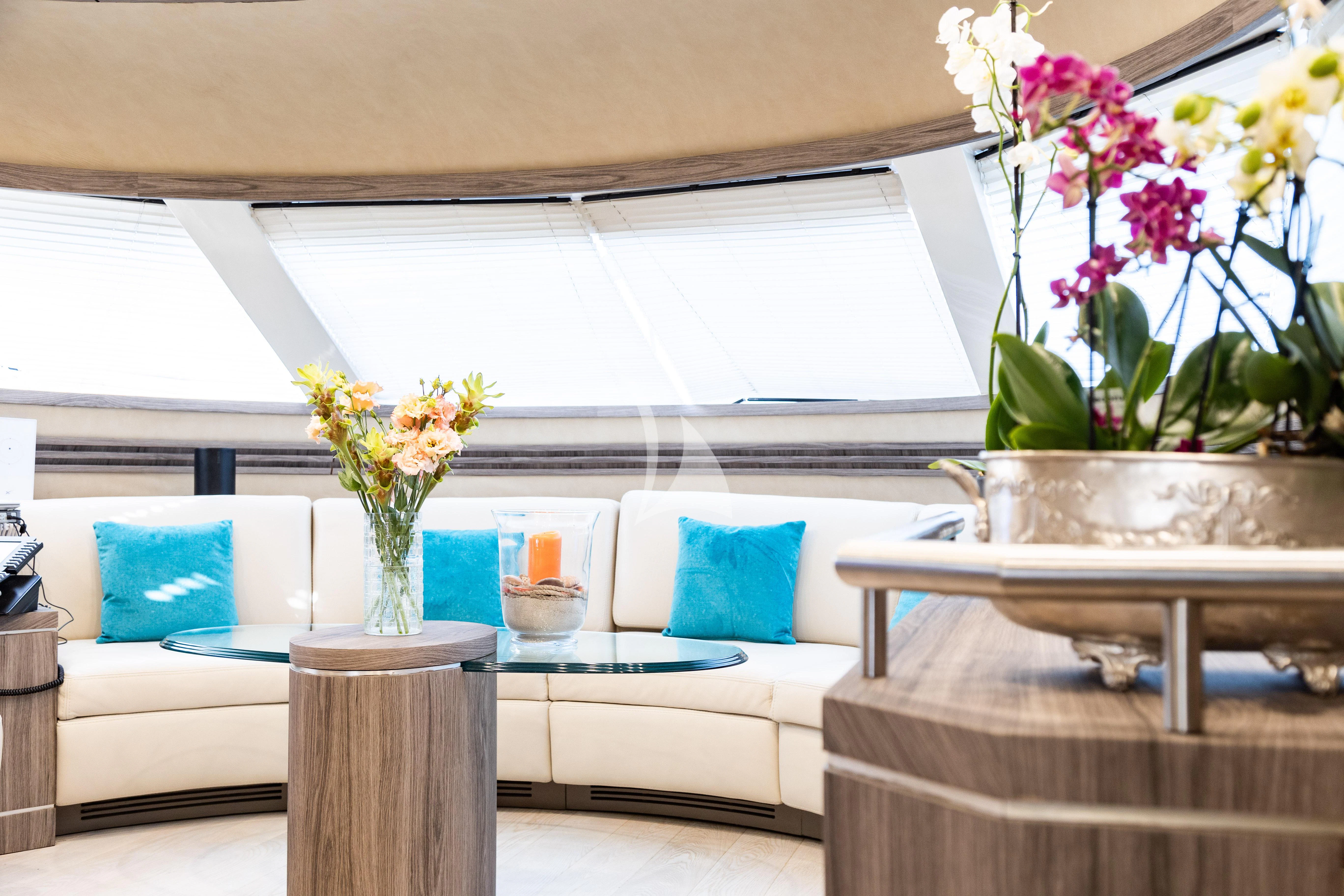 a living room with a white couch and a vase with flowers aboard LADY B Yacht for Charter