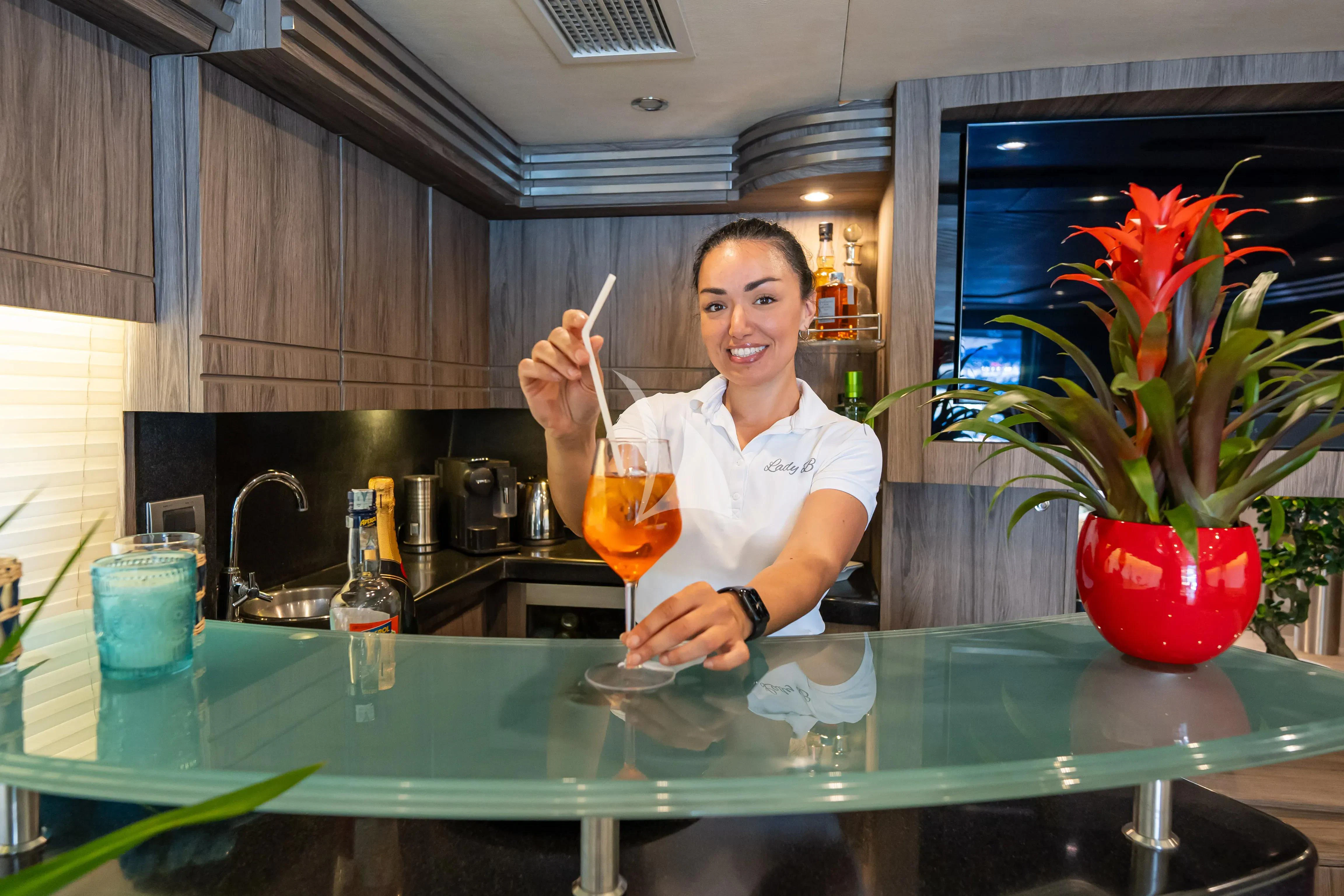 a person sitting at a table with a glass of orange juice aboard LADY B Yacht for Charter