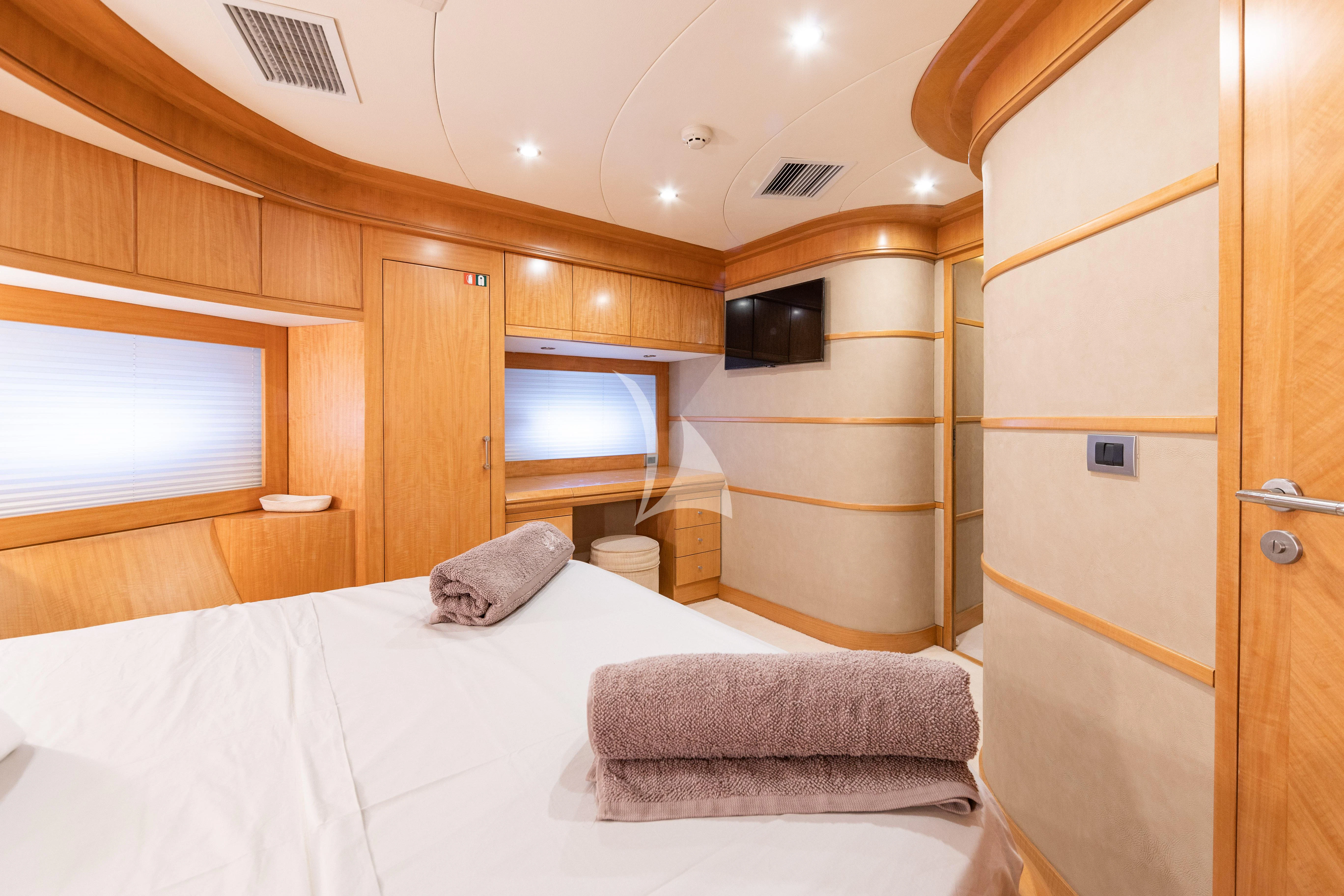 a bedroom with a bed and a television aboard LADY B Yacht for Charter