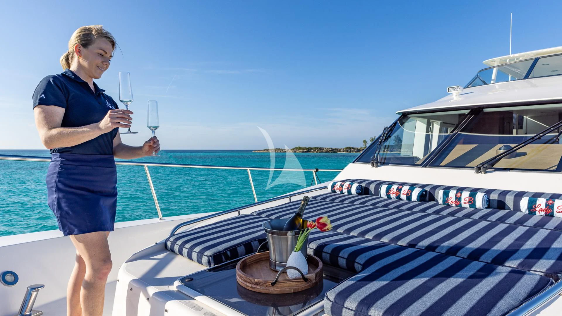 a woman standing on a deck with a drink and a cup aboard LADY B Yacht for Charter