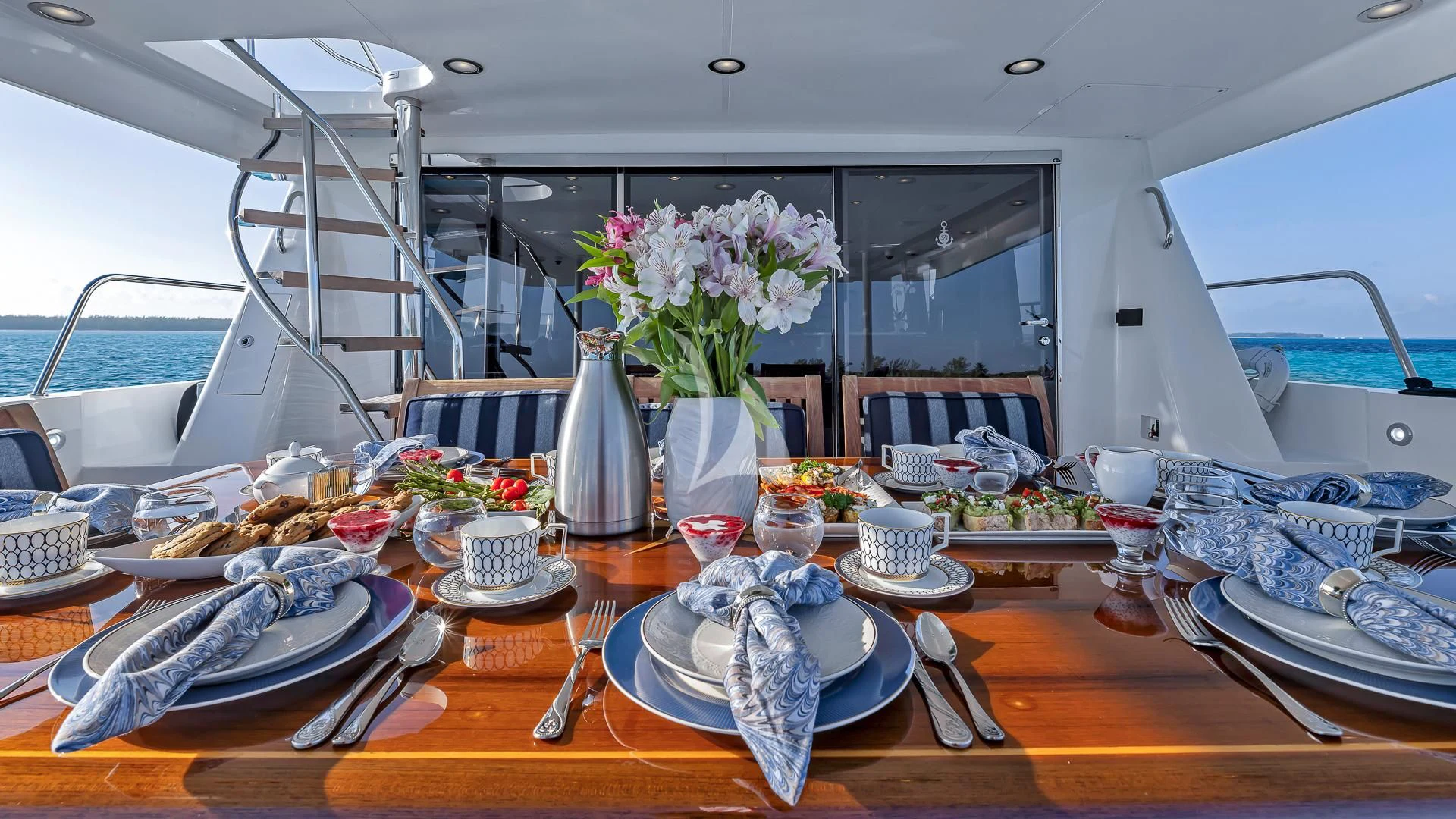 a table with plates and flowers aboard LADY B Yacht for Charter