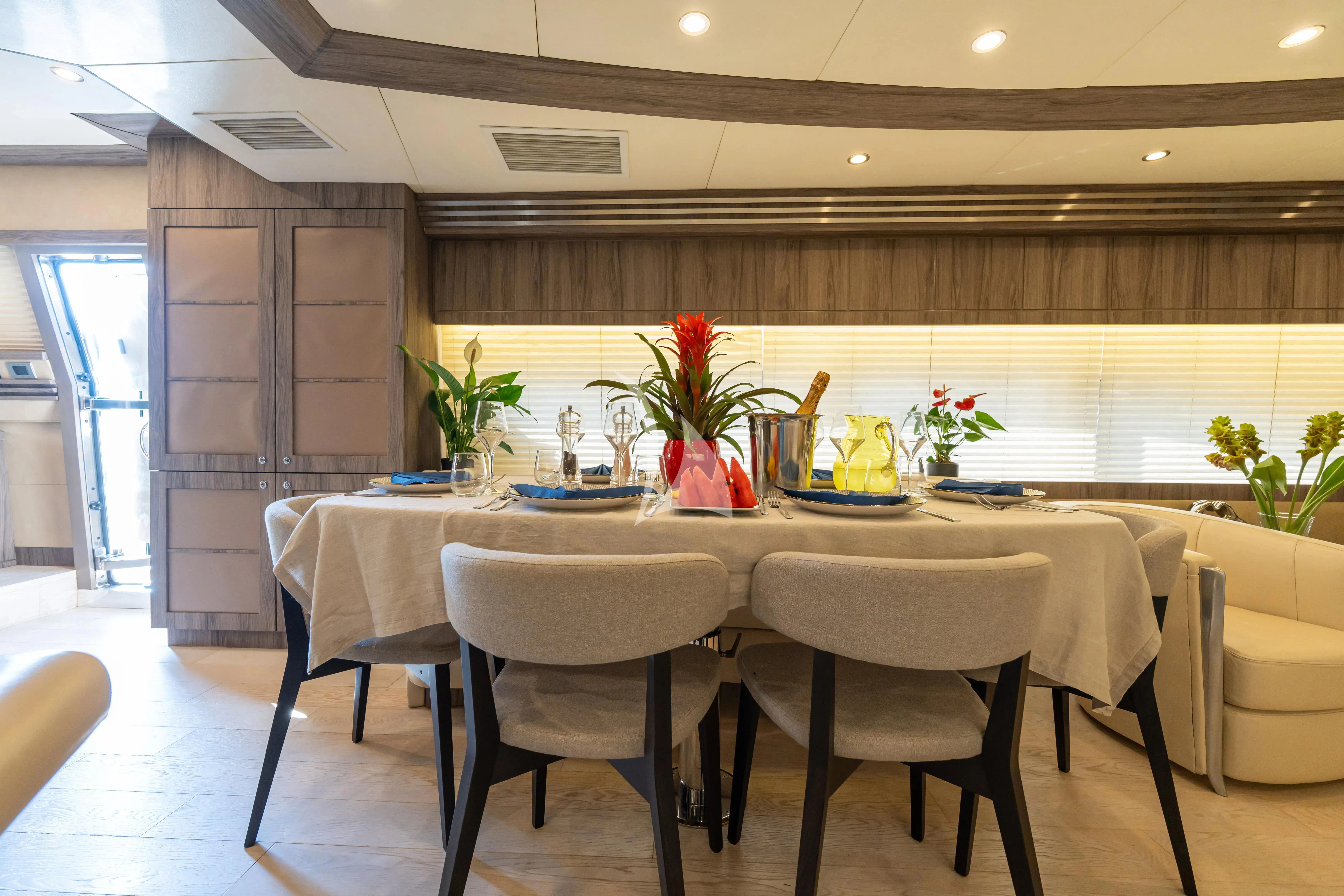 a table with chairs and a vase with flowers on it aboard LADY B Yacht for Charter