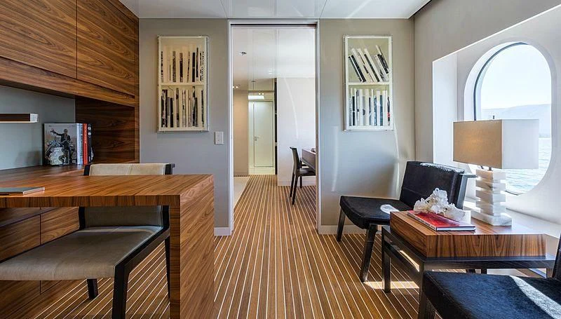 a room with a wood floor and a wood table and chairs aboard CHASSEUR Yacht for Charter