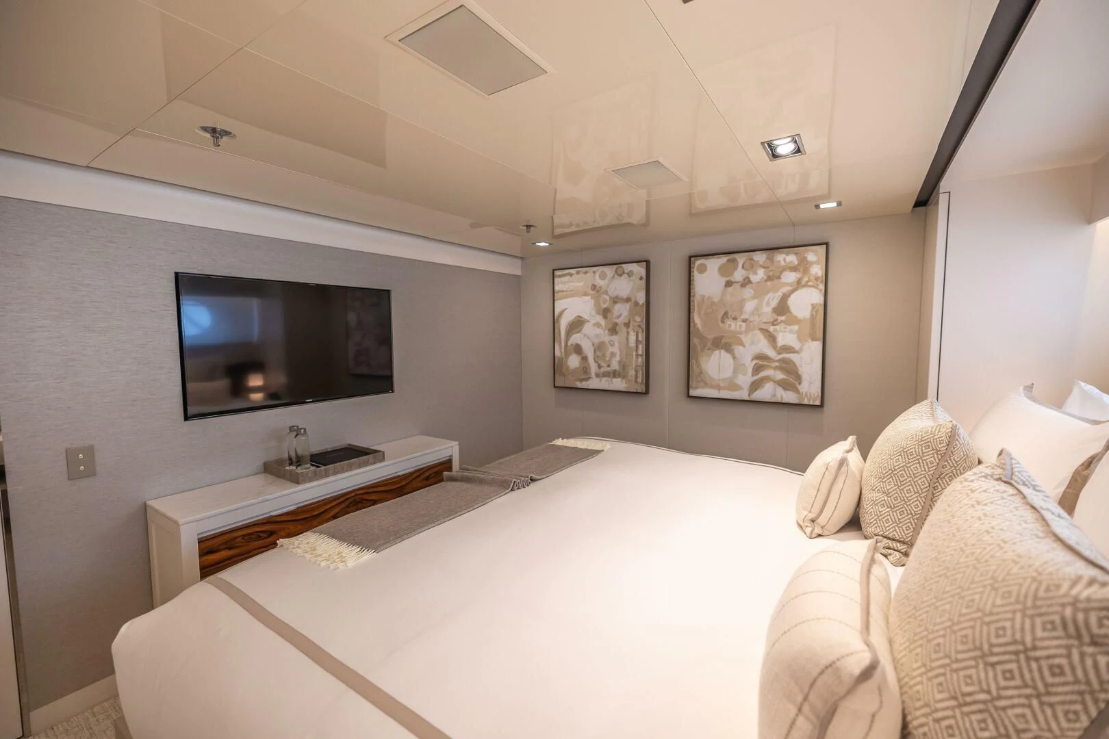 a bedroom with a bed and a tv on the wall aboard CHASSEUR Yacht for Charter