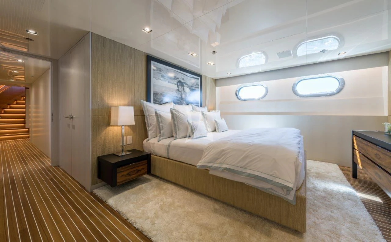 a room with a bed and a lamp aboard CHASSEUR Yacht for Charter