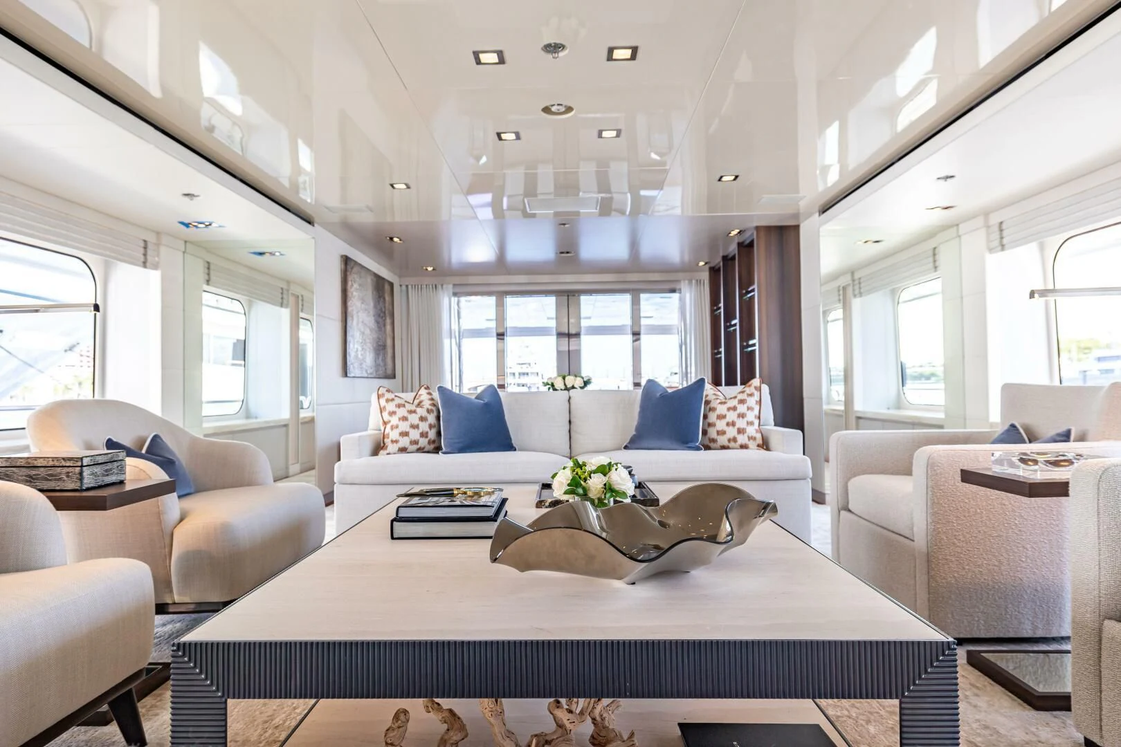 a large white living room with a large white table and chairs aboard CHASSEUR Yacht for Charter