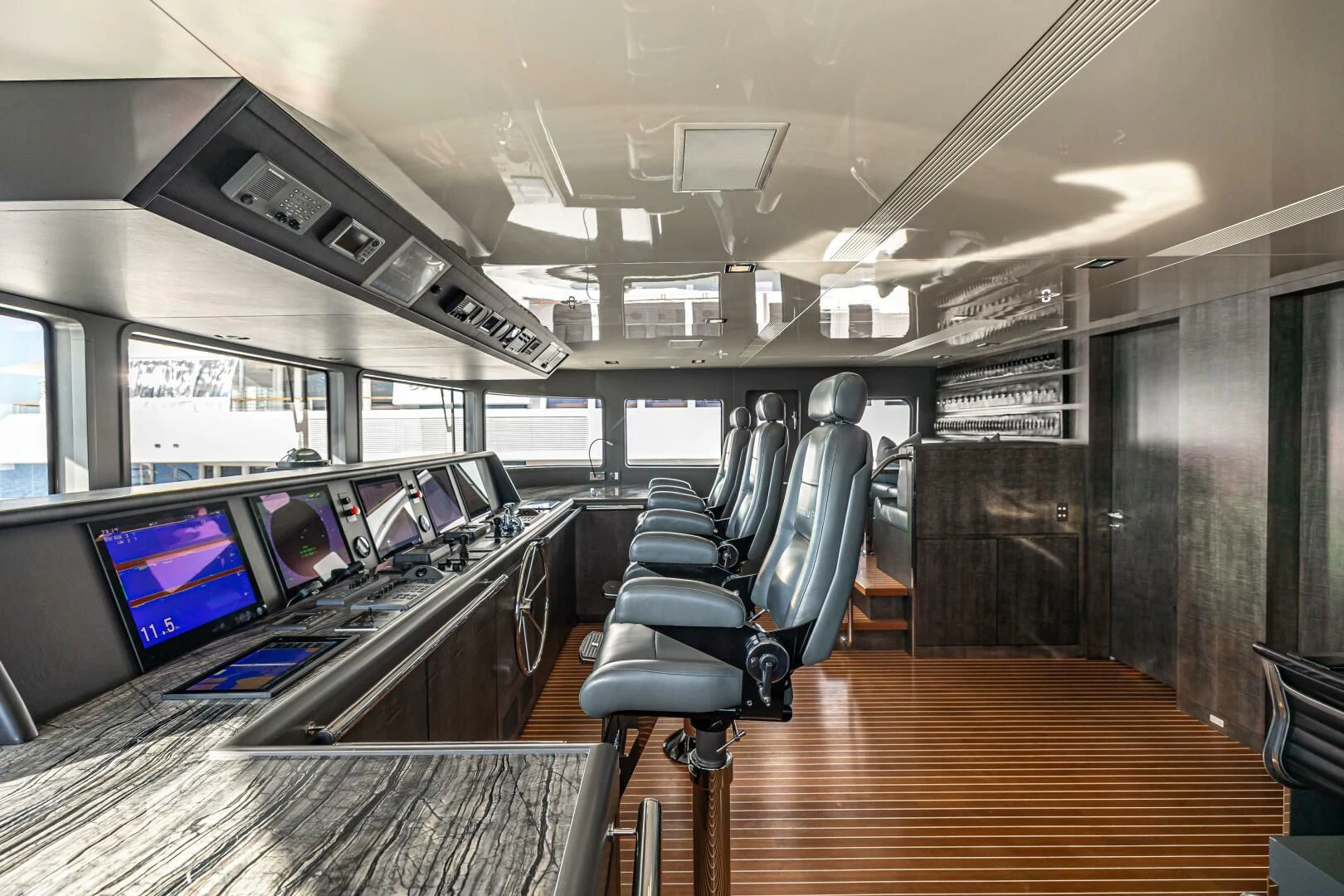 a room with a row of computer screens and chairs aboard CHASSEUR Yacht for Charter