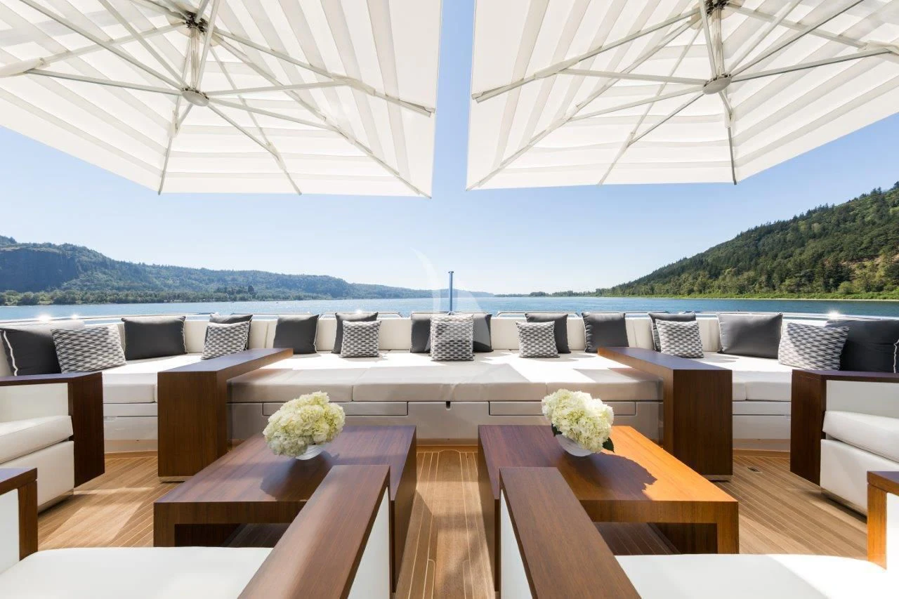 a large patio with a large white tent and a table with chairs aboard CHASSEUR Yacht for Charter