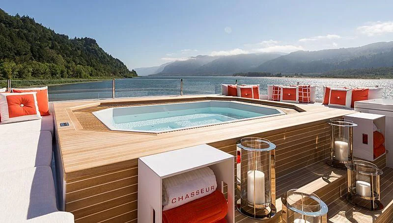 a large pool with a deck overlooking a large body of water aboard CHASSEUR Yacht for Charter