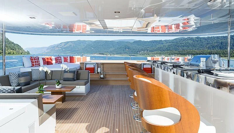 a room with a table chairs and a boat in the water aboard CHASSEUR Yacht for Charter