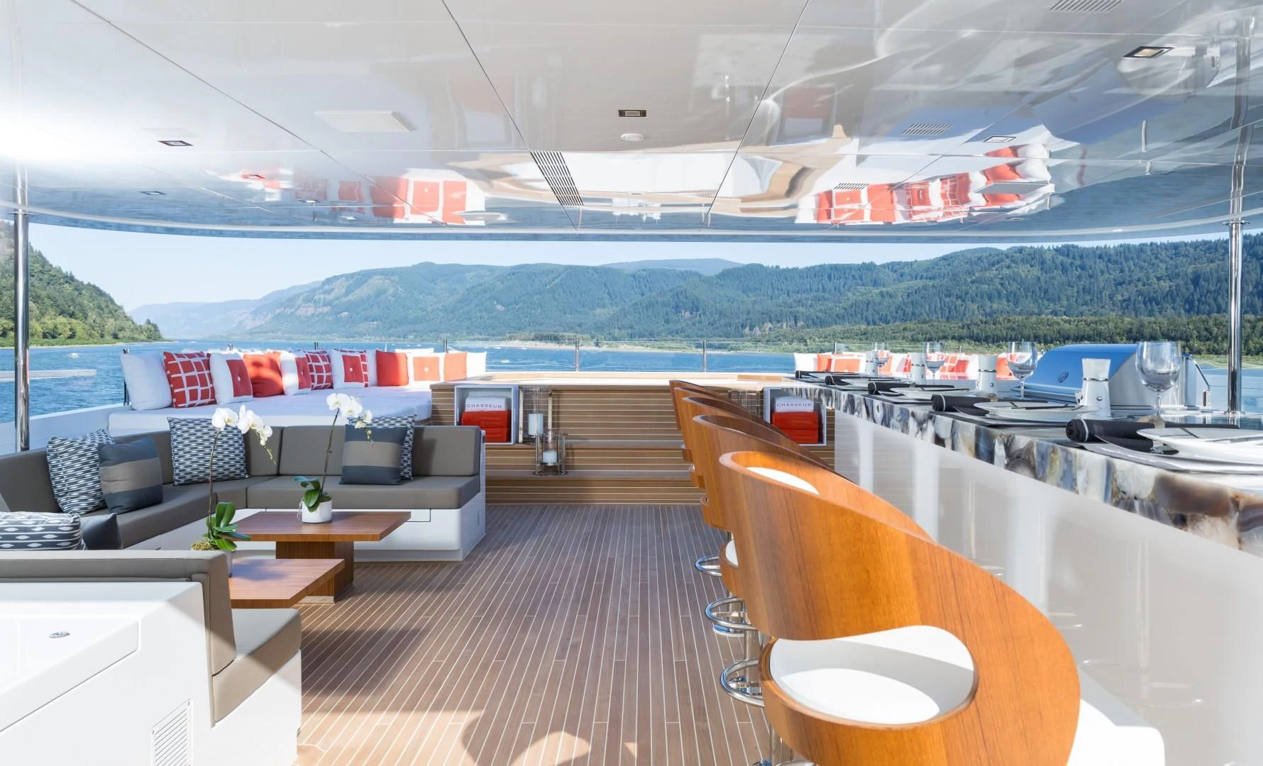 a large lounge area with a large boat in the background aboard CHASSEUR Yacht for Charter
