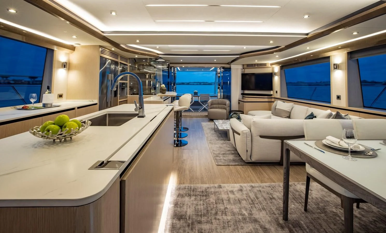 a large room with a table and couches aboard PLANE TO SEA Yacht for Sale