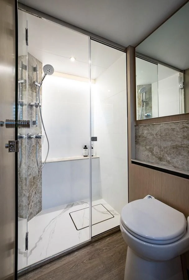 a bathroom with a glass shower aboard PLANE TO SEA Yacht for Sale