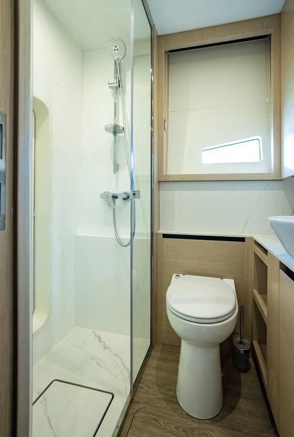 a bathroom with a glass shower door aboard PLANE TO SEA Yacht for Sale