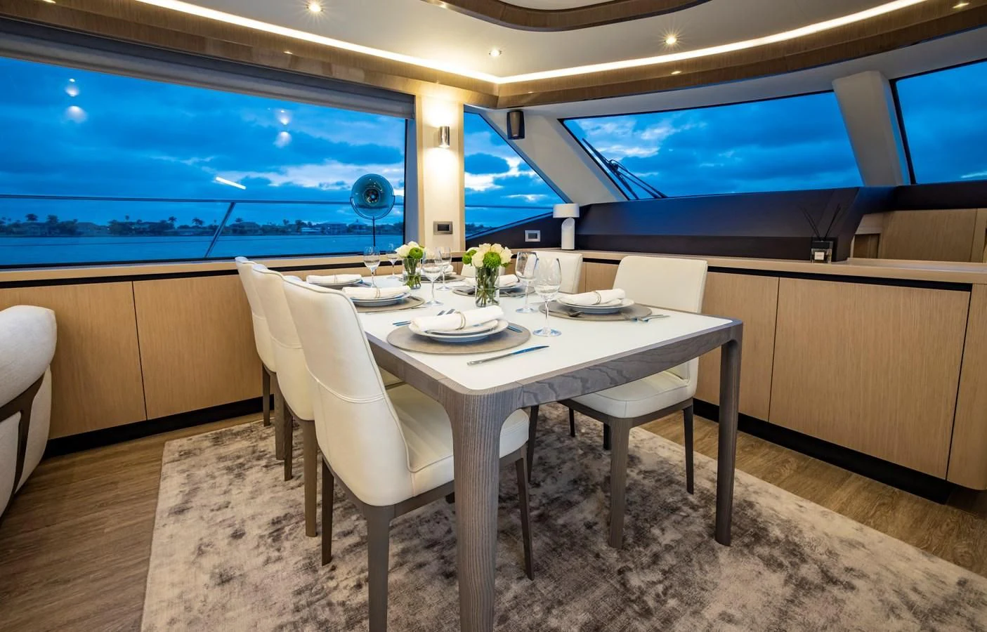 a table with chairs and a television in the background aboard PLANE TO SEA Yacht for Sale