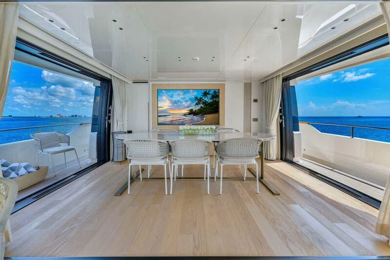 a room with a table chairs and a large window aboard JICJ Yacht for Sale