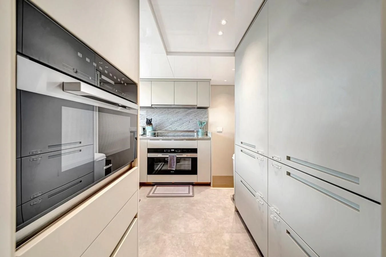 a kitchen with white cabinets aboard JICJ Yacht for Sale