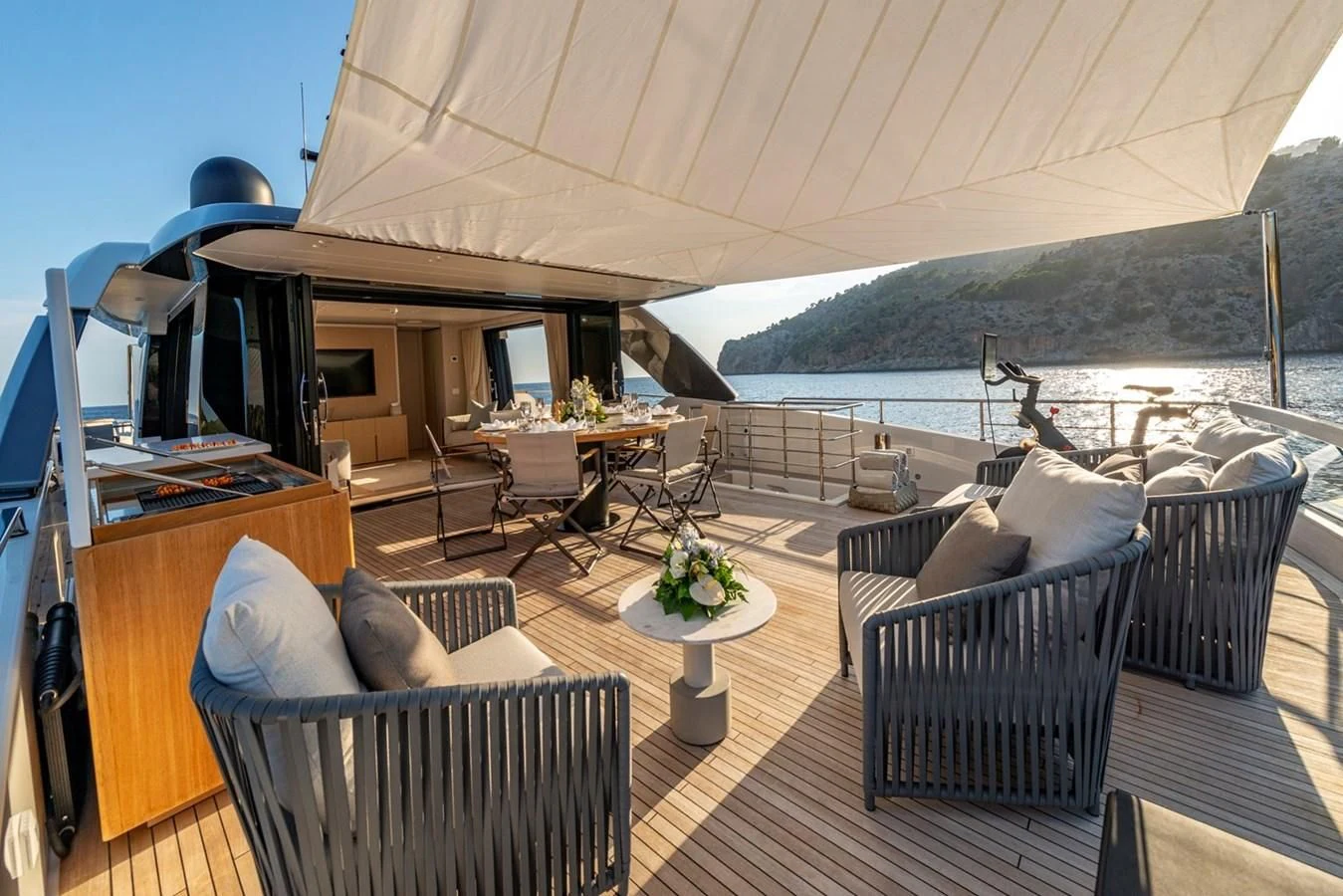 a deck with a table chairs and a large body of water aboard JICJ Yacht for Sale
