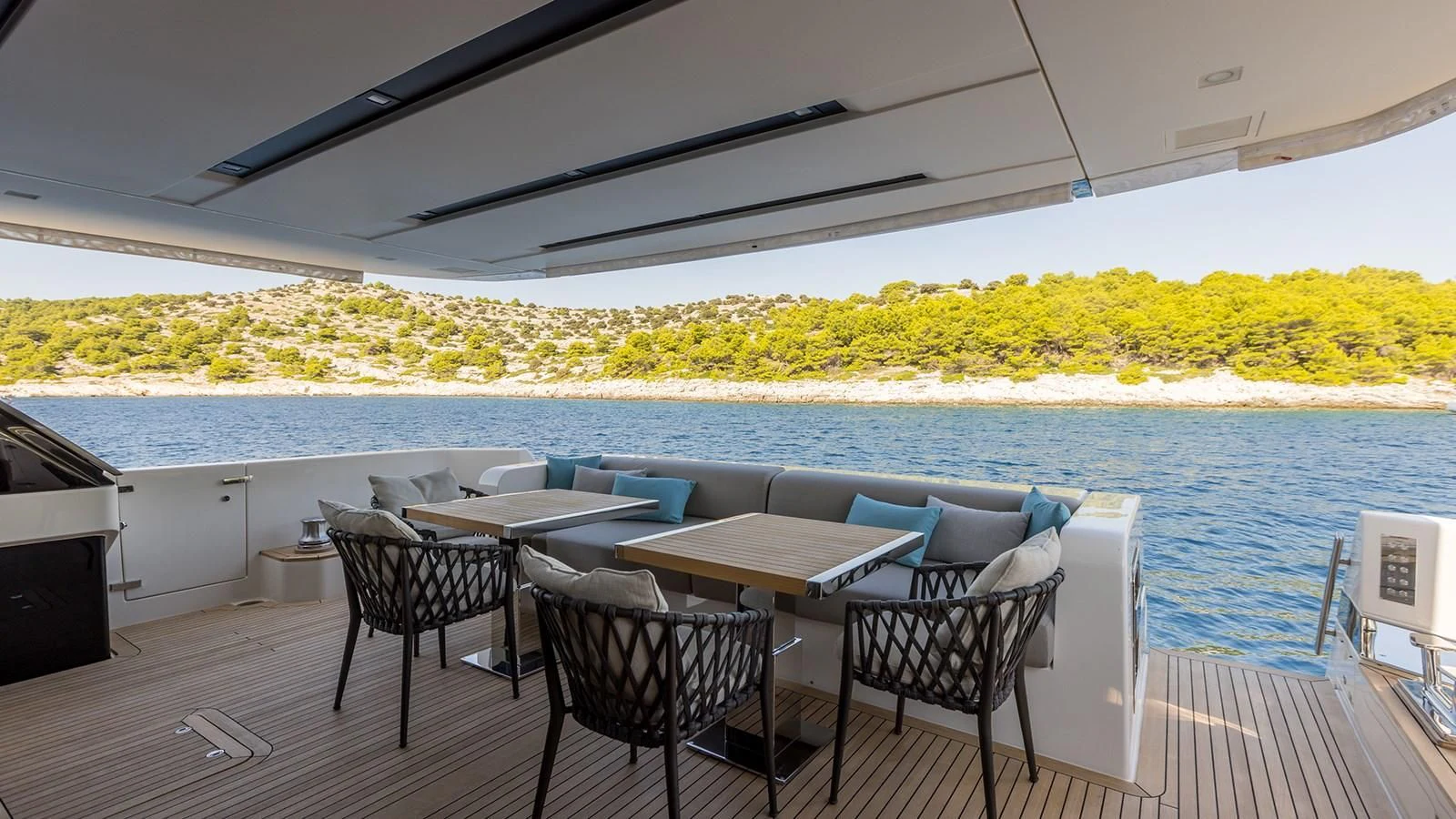 a table and chairs on a deck overlooking a body of water aboard JICJ Yacht for Sale