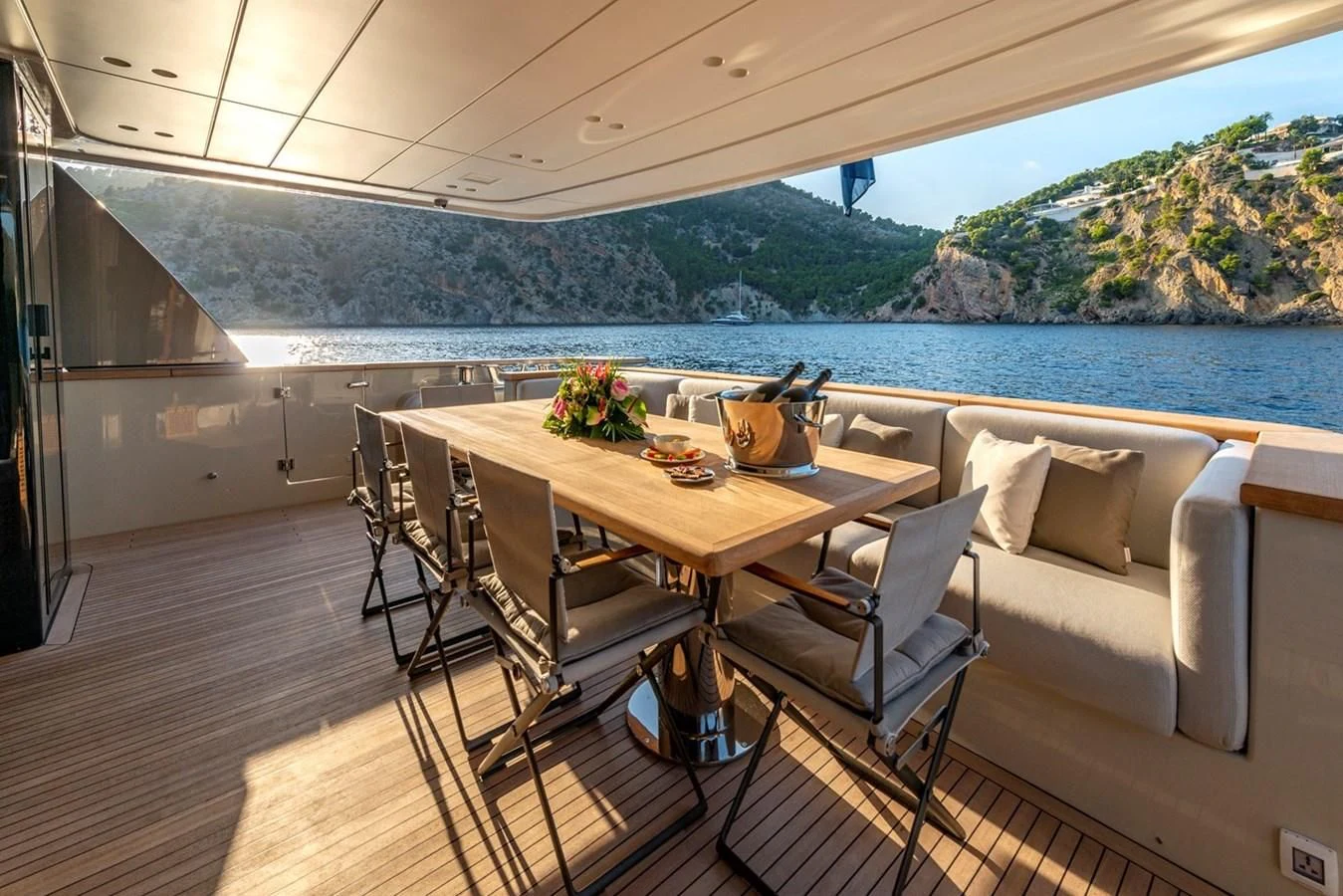 a dining table on a balcony overlooking a body of water aboard JICJ Yacht for Sale