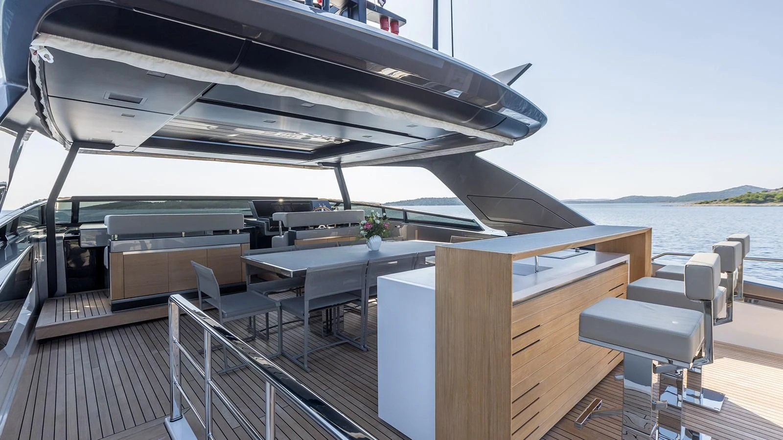 a deck with a table and chairs on it aboard JICJ Yacht for Sale