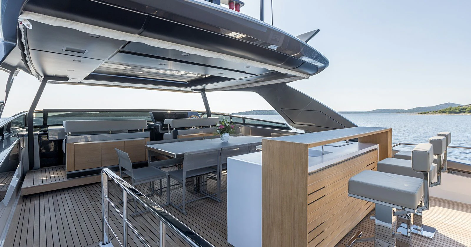 a deck with a table and chairs on it aboard JICJ Yacht for Sale