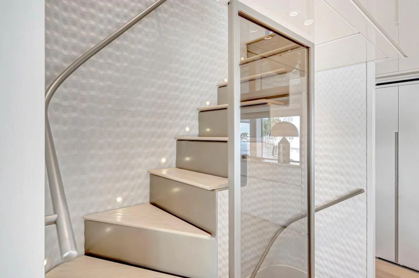 a white staircase with a glass door aboard JICJ Yacht for Sale