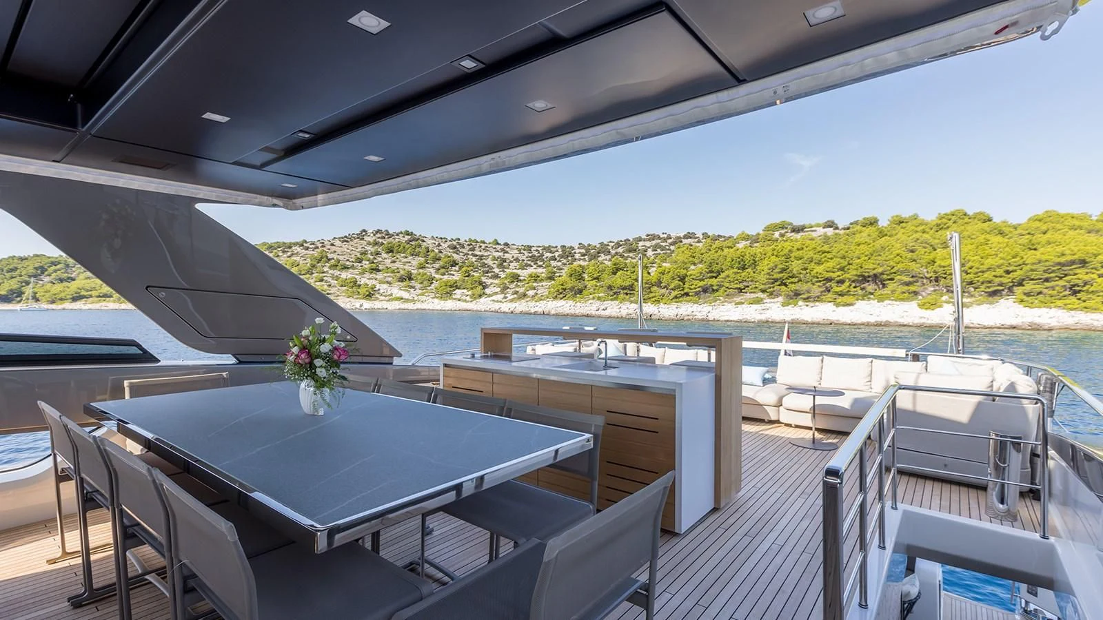 a deck with a table and chairs on it aboard JICJ Yacht for Sale