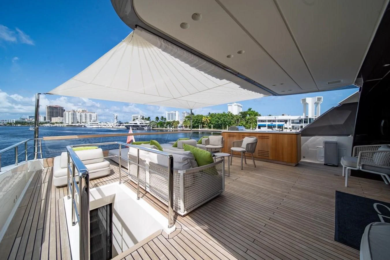 a deck with a large white tent and a pool with chairs and a large white building with a aboard JICJ Yacht for Sale