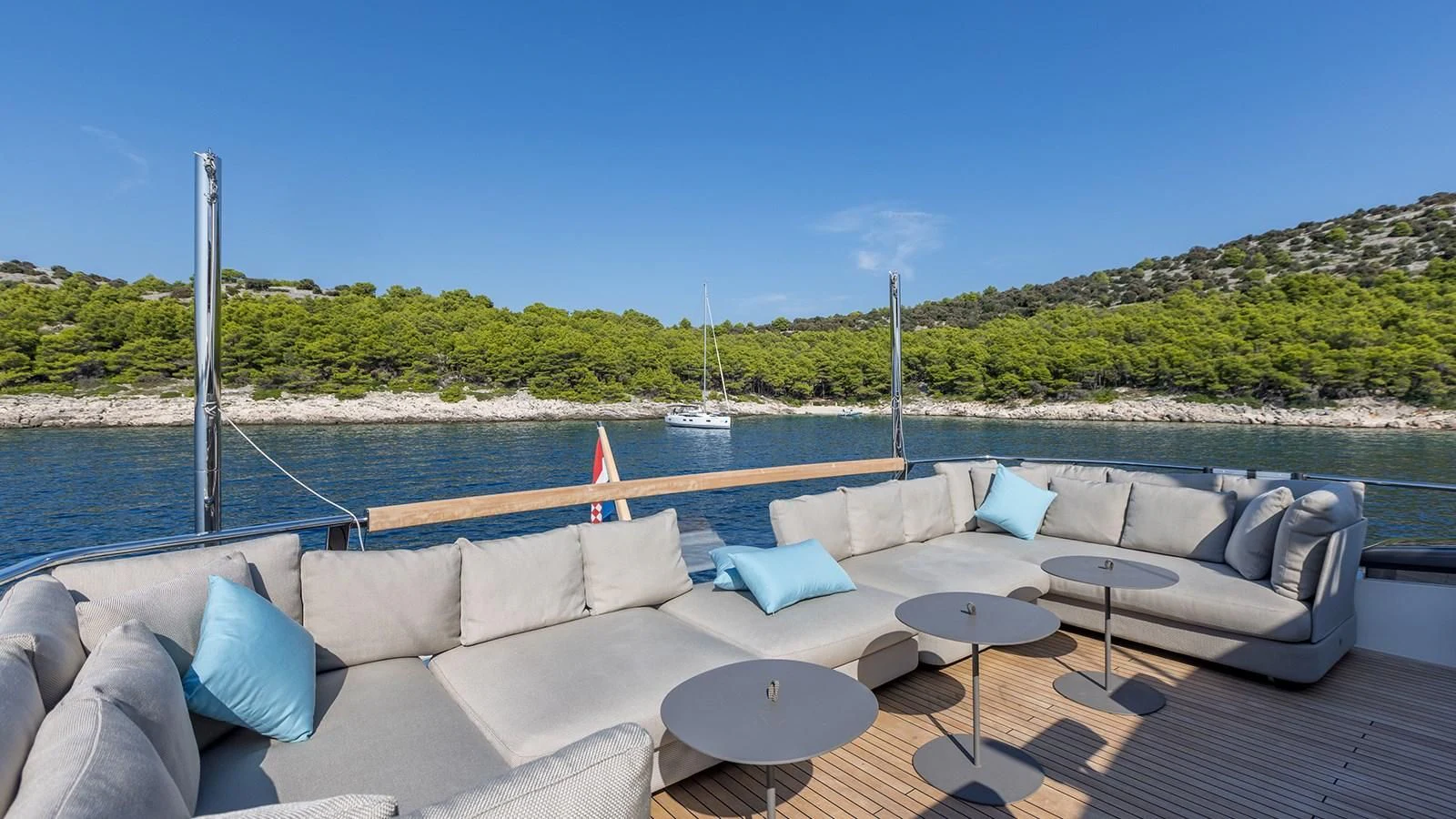 a couch and table on a deck overlooking a body of water aboard JICJ Yacht for Sale
