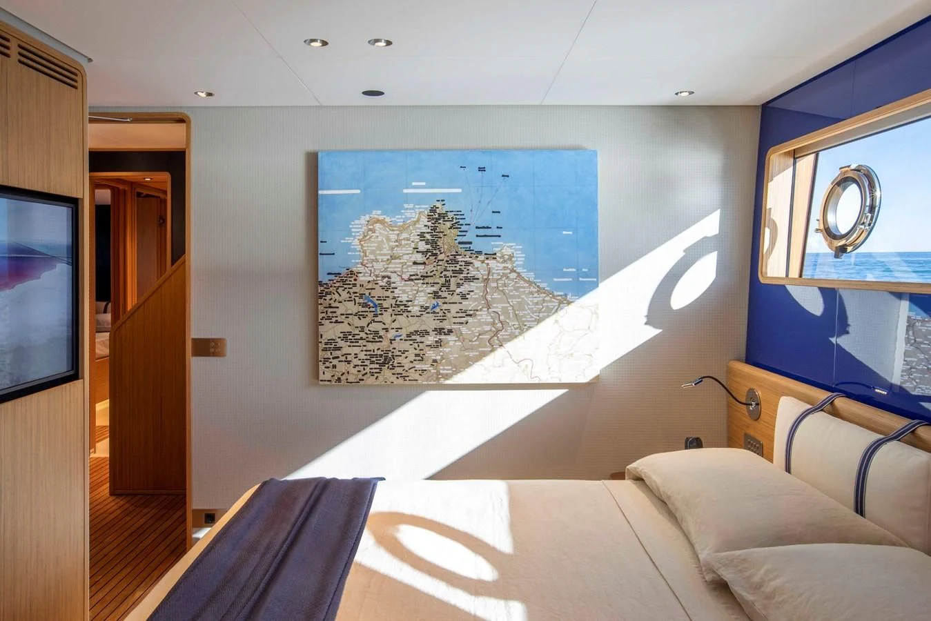 a bed with a painting on the wall aboard MIA CA Yacht for Sale