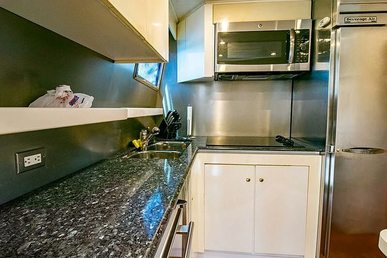 a kitchen with stainless steel appliances aboard ALMAR Yacht for Sale