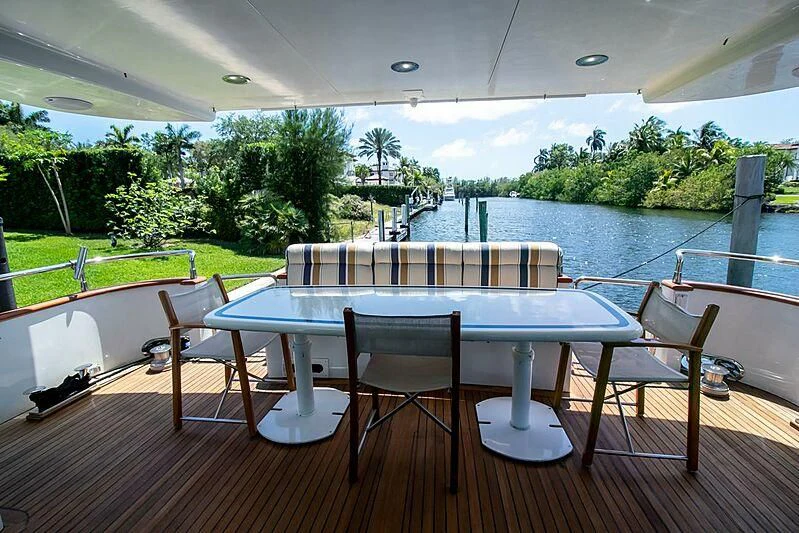 a table and chairs on a deck overlooking a pool aboard ALMAR Yacht for Sale