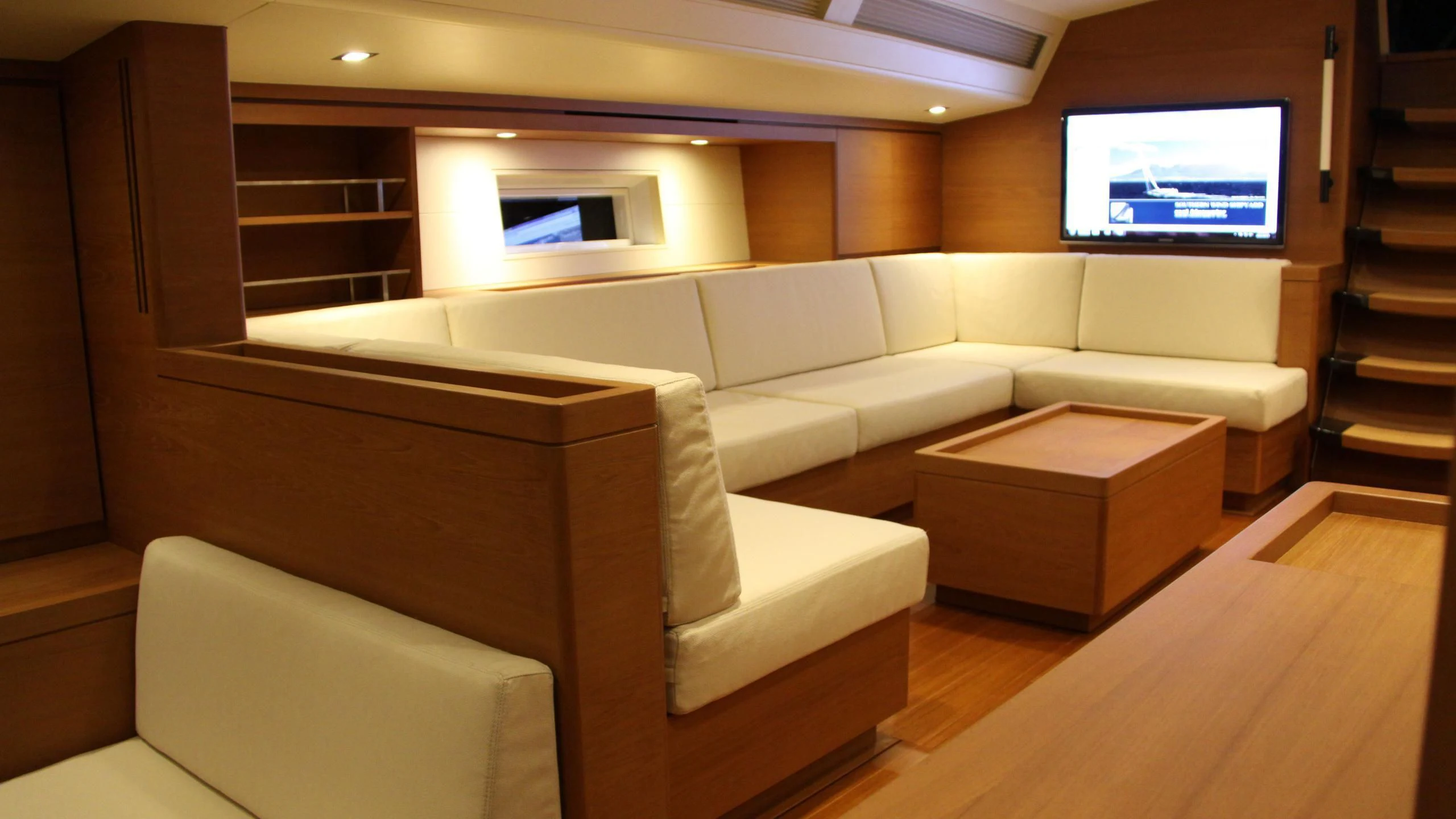 a room with a couch and a tv on the wall aboard GRILLO PARLANTE Yacht for Sale