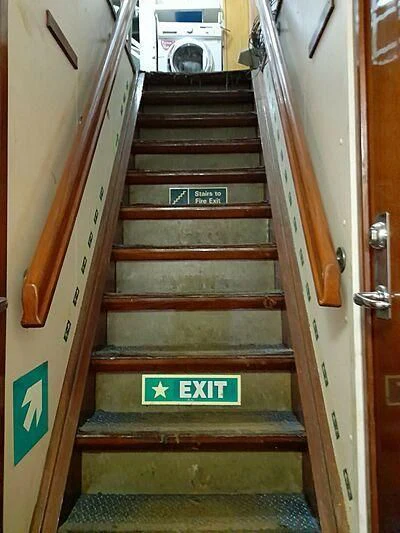a wooden staircase with a sign on the side aboard EVANGELIYA Yacht for Sale
