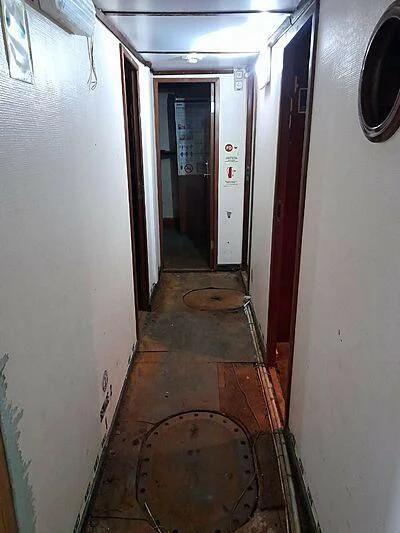 a dirty hallway with a broken wall aboard EVANGELIYA Yacht for Sale