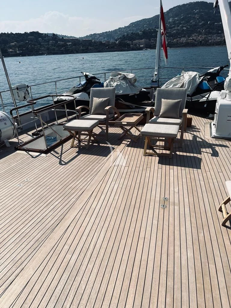 a deck with chairs and tables on it by a body of water aboard SOUTH PAW C Yacht for Sale