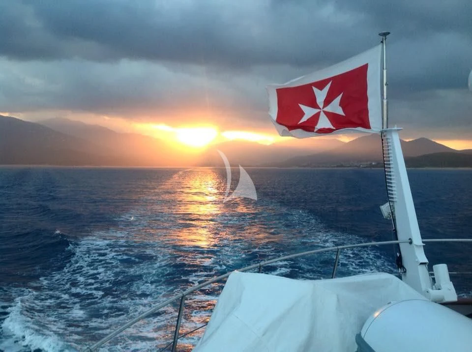 a flag on a flagpole on a ship in the ocean aboard SOUTH PAW C Yacht for Sale