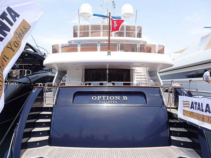 a boat with a flag on the deck aboard OPTION B Yacht for Charter
