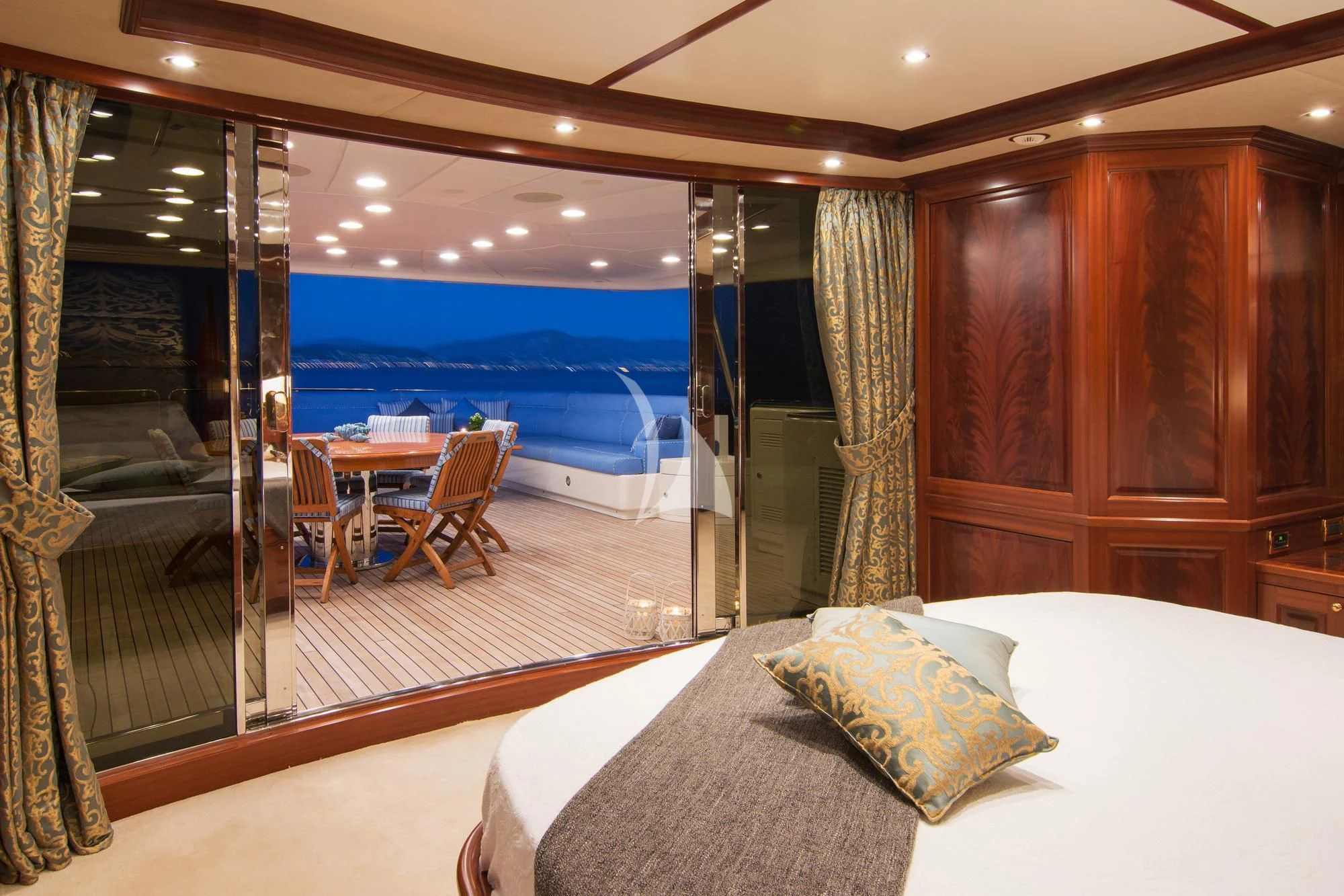 a room with a bed and a table and chairs aboard OPTION B Yacht for Charter