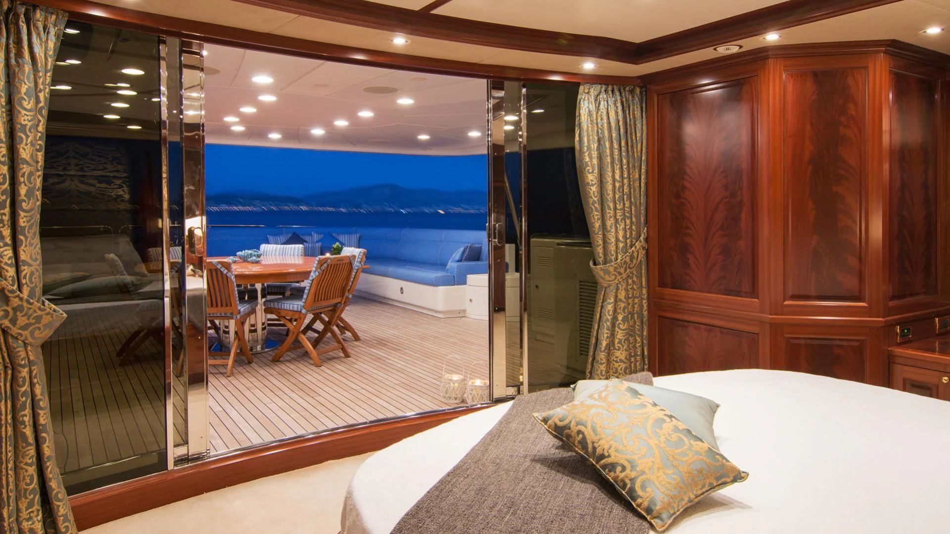 a room with a bed and a table and chairs aboard OPTION B Yacht for Charter